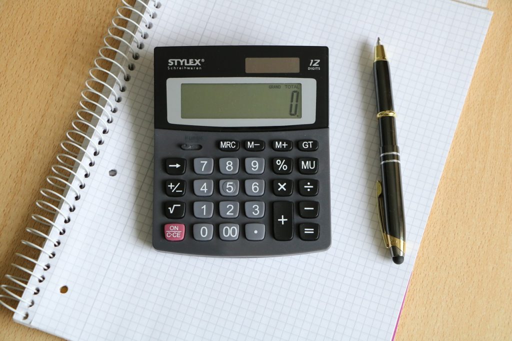 calculator and pen resting on notebook